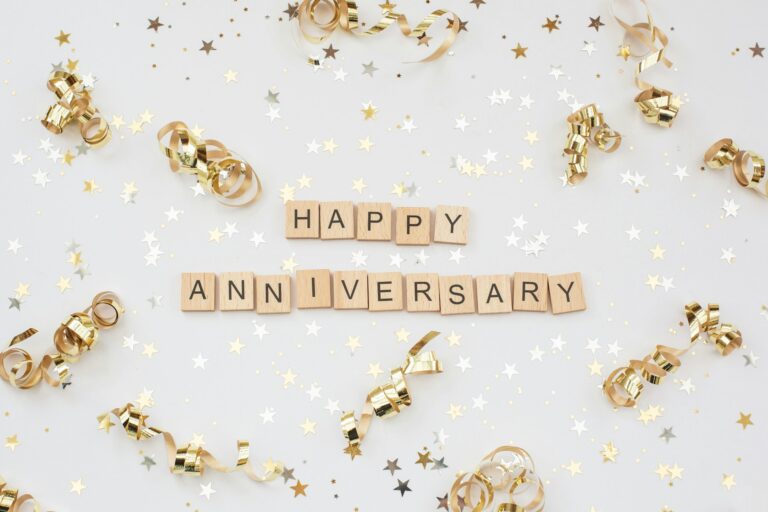 A festive looking background, with gold star trimmings and gold spirals with happy anniversary right at the center.